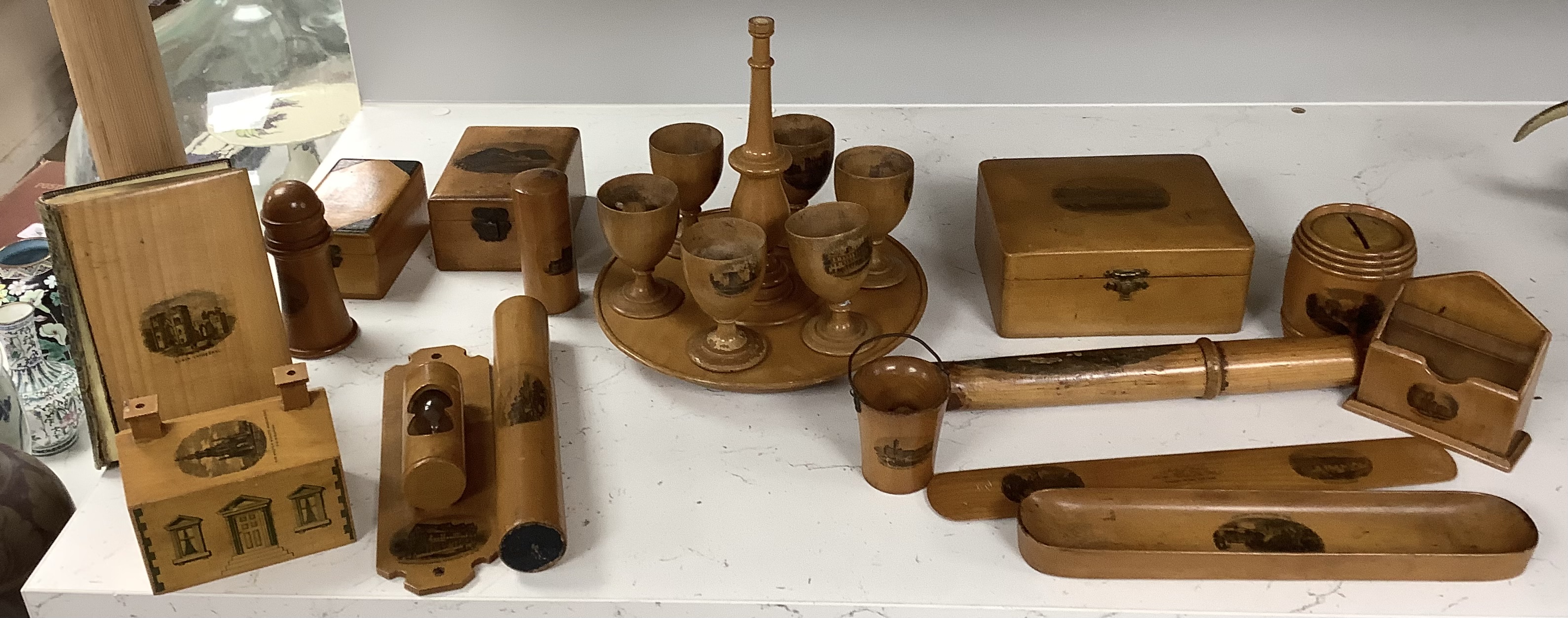 A collection of mixed Mauchline wares, including six egg cups on stand, a house money box, various boxes, letter openers and a Scottish song book, 14cm high (16)